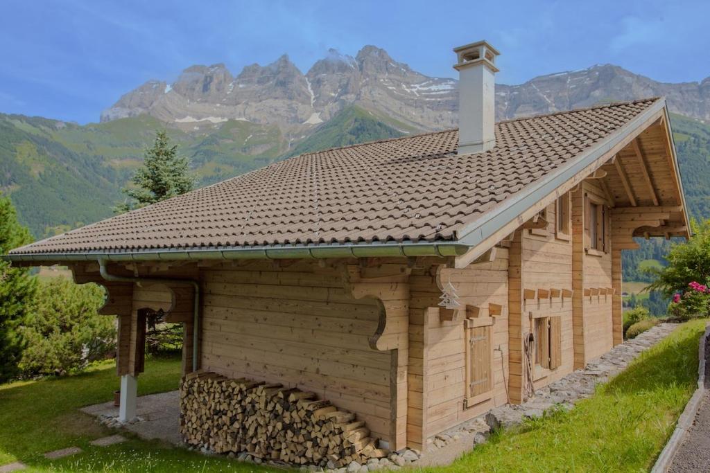 una pequeña casa de madera con montañas en el fondo en Chalet l'Orchidée, en Champéry