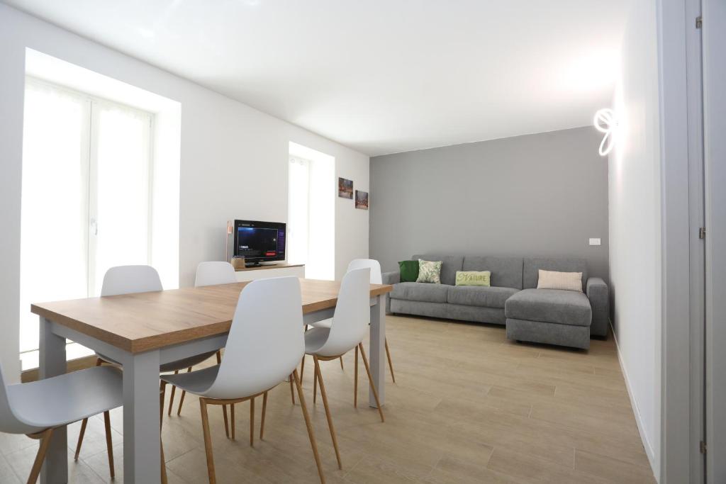 Casa BEA 1 في كاستوني ديلا بريسولانا: غرفة طعام مع طاولة وكراسي بيضاء