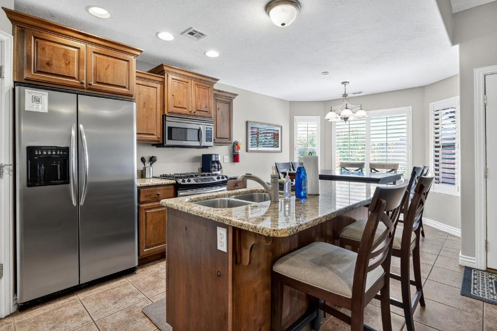 a kitchen with stainless steel appliances and wooden cabinets at Cozy Desert Retreat Near Zion - Patio Dininggrill in La Verkin