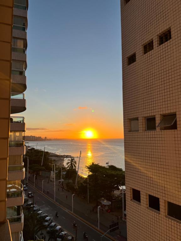Una puesta de sol vista desde una ventana de un edificio en Quarto na Av Beira mar em um Apto familiar, en Fortaleza
