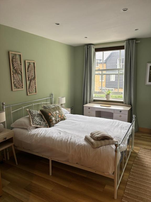 a bedroom with a bed and a large window at Cosy central hideout in Ware