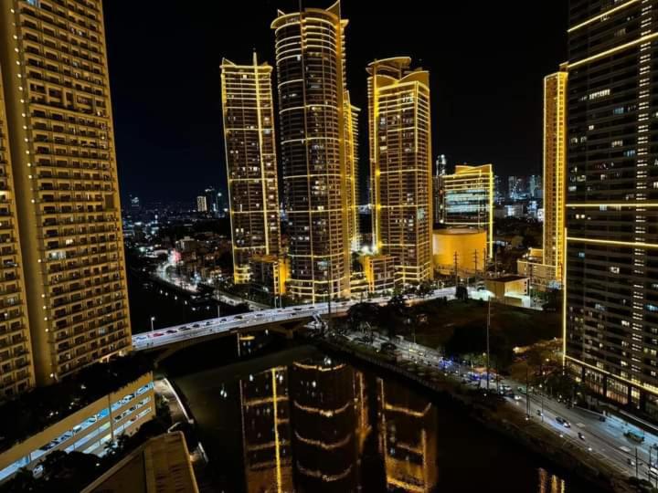 a view of a city at night with buildings at Aveline Suites Sunrise 2bedroom in Manila