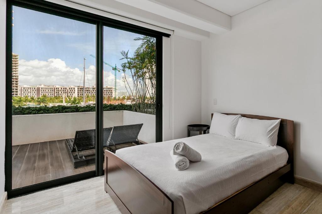 a bedroom with a bed and a balcony at 2 BR Apartment in Marina Condo in Cancún