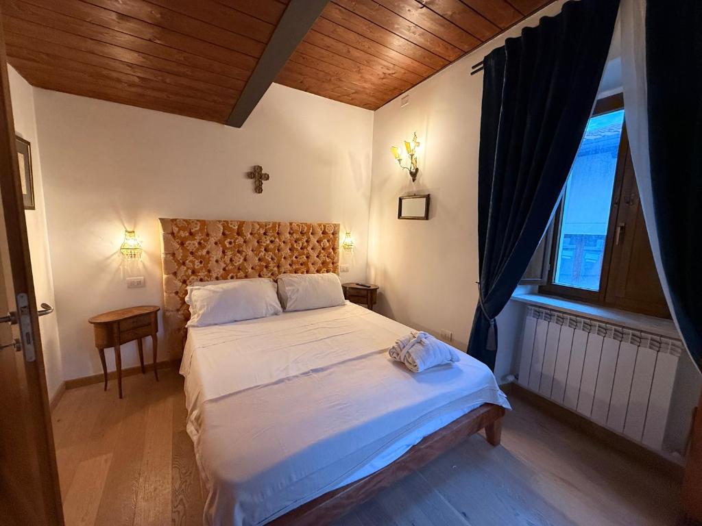 a bedroom with a large bed and a window at Visione Piazzetta Alferi 2 in LʼAquila