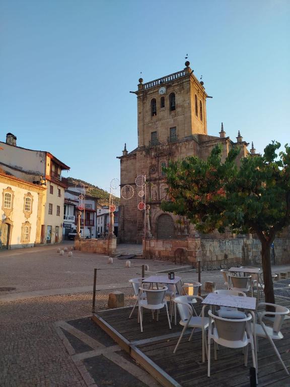 a group of tables and chairs in front of a building at Douro & Sabor Escape in Torre de Moncorvo