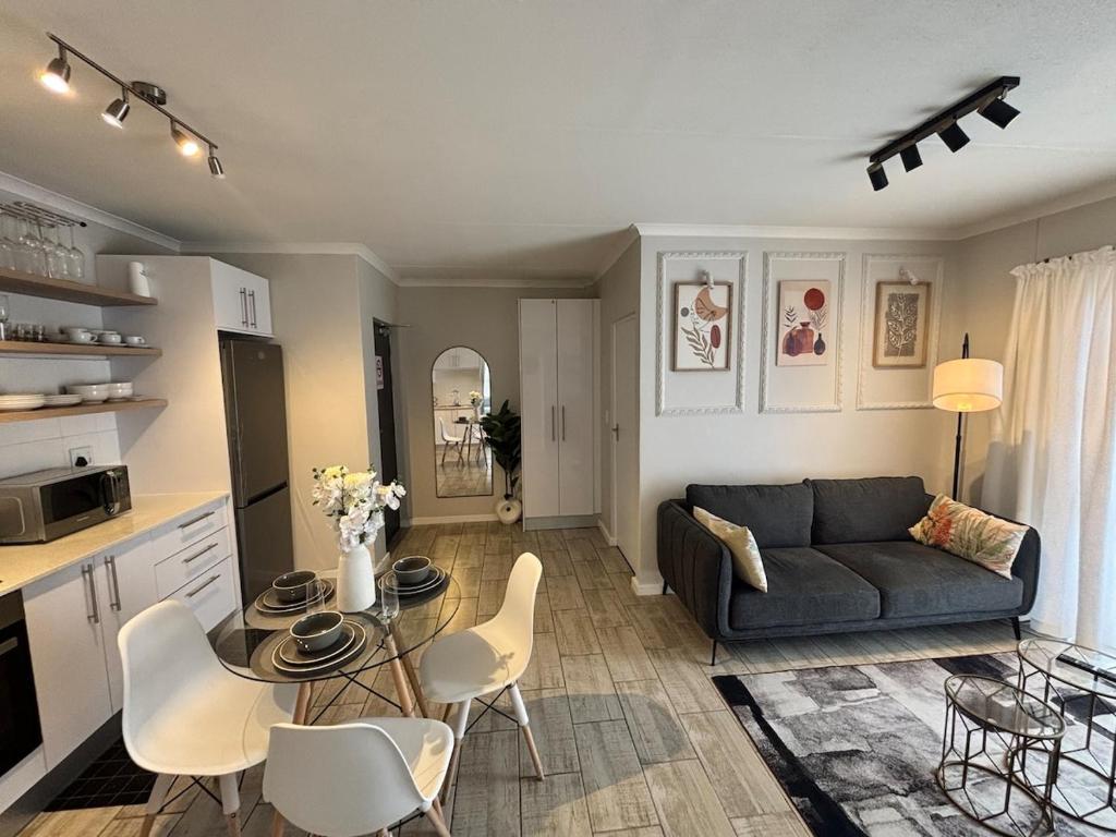 a living room with a couch and a table and chairs at Seabreeze Summit Retreat Your Perfect Escape in Cape Town