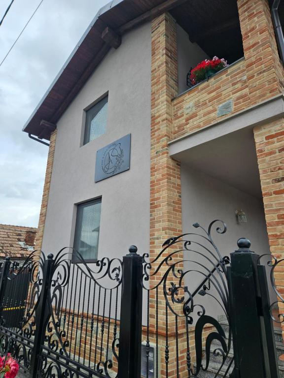 a building with a gate with a clock on it at Ale&Sere Housing in Jiblea Nouă