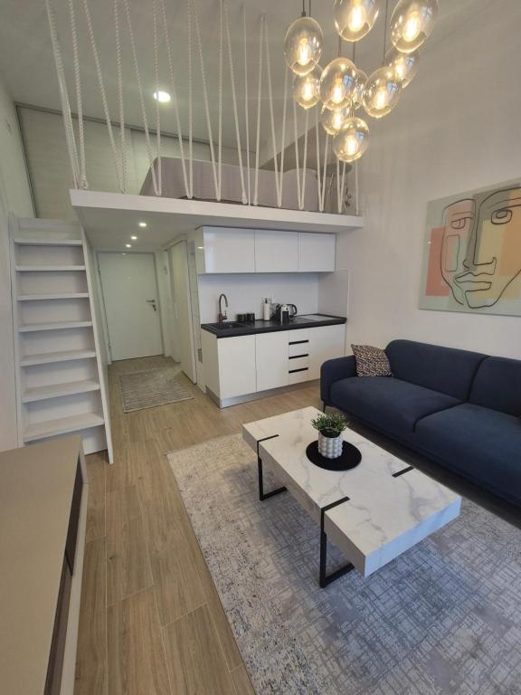 a living room with a blue couch and a table at Lux Studio Porto in Tivat
