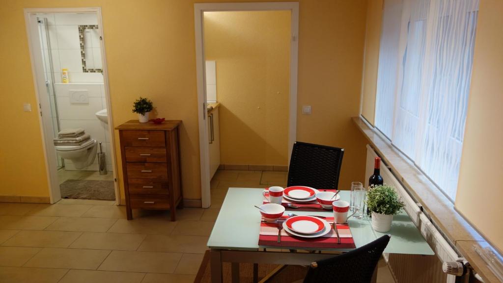 a dining room with a table and chairs and a bathroom at Nürnberg Apart - Business Apartment in Nürnberg