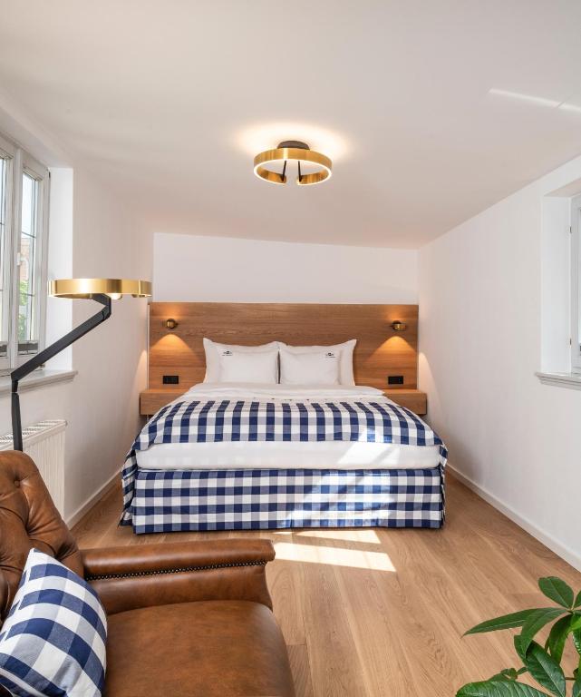 ein Schlafzimmer mit einem Bett und einer Couch in der Unterkunft Hästens Suites - chez Douverne in Sommerach