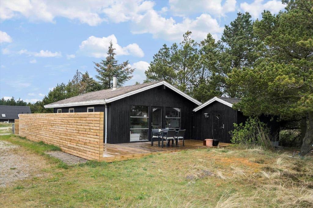 a black and wooden house with a wooden deck at 1014-Thisted-Sletningen-7 in Torsted