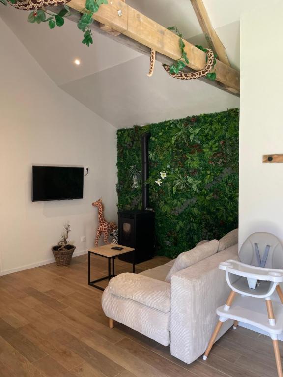 a living room with a couch and a green wall at La jungle in Saint-Nicolas-dʼAliermont