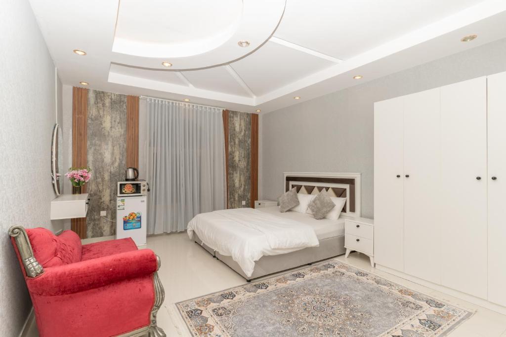 a bedroom with a bed and a red chair at شقق ابحر المفروشه in Jeddah