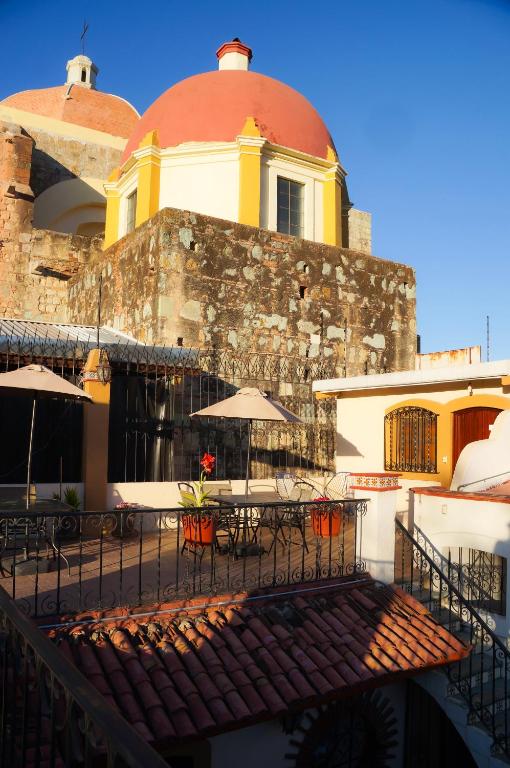 Hotel Casa de Alicia Departamento Yagul, an outdoor patio with tables and umbrellas in front of a building at Casa de Alicia Departamento Yagul in Oaxaca City