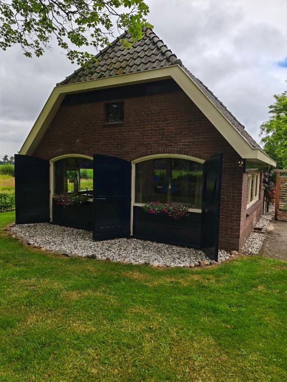 a red brick house with two large windows at Vakantiehuisje 'De Uithof' in Oosterhesselen