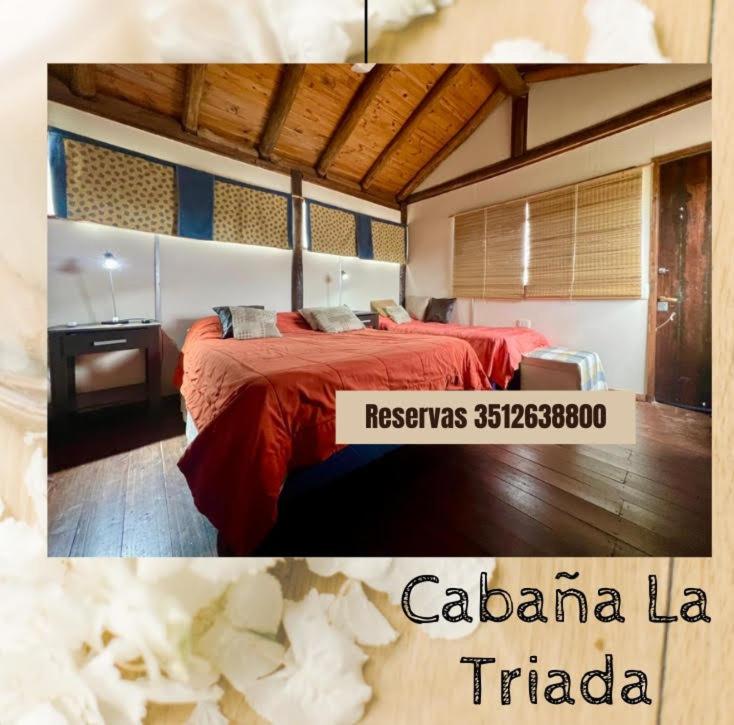 a hotel room with a red bed at Cabaña La Triada Pileta Privada Grupo Cabaña La Triada in Río Ceballos