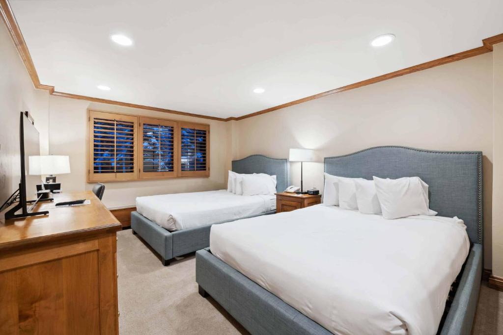 a hotel room with two beds and a desk at Lodge Tower 283 in Vail