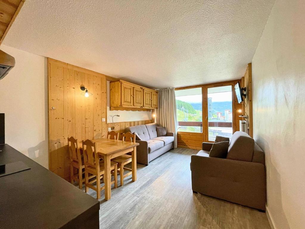 une cuisine et un salon avec une table et un canapé dans l'établissement Résidence Chaviere - Chaleureux studio situé au coeur des Menuires au pied des pistes MAE-5754, aux Menuires