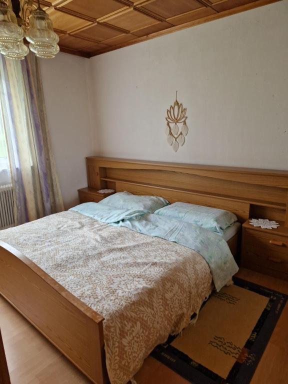a bedroom with a bed with a wooden head board at Ferienwohnung im Dörfl in Mooslandl