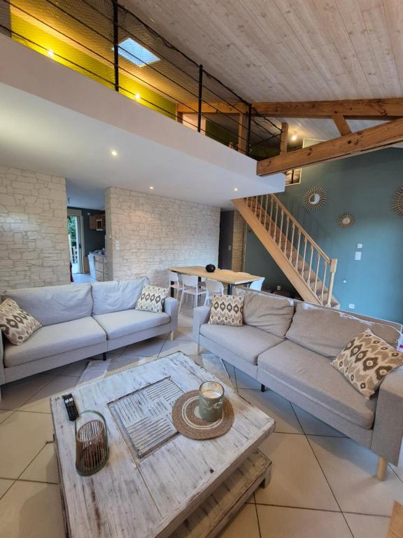 ein Wohnzimmer mit Sofa und Tisch in der Unterkunft Maison de Gare, 8 personnes, 20 min PUY du F in Mouchamps