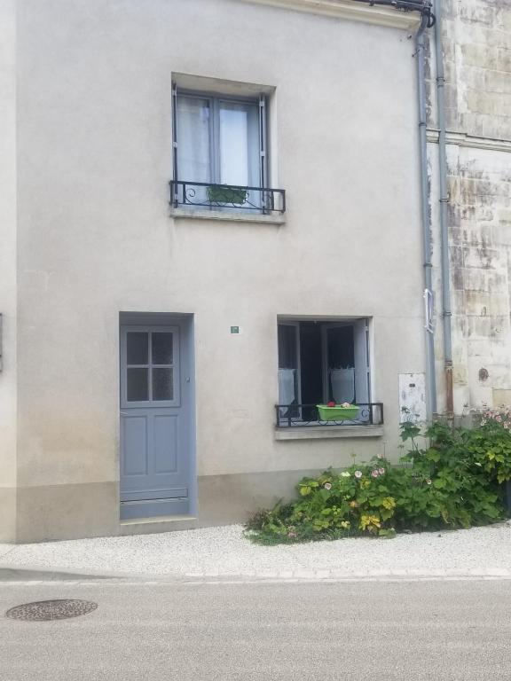 - un bâtiment blanc avec une porte bleue et 2 fenêtres dans l'établissement Au Cœur de Lignières, à Lignières-de-Touraine