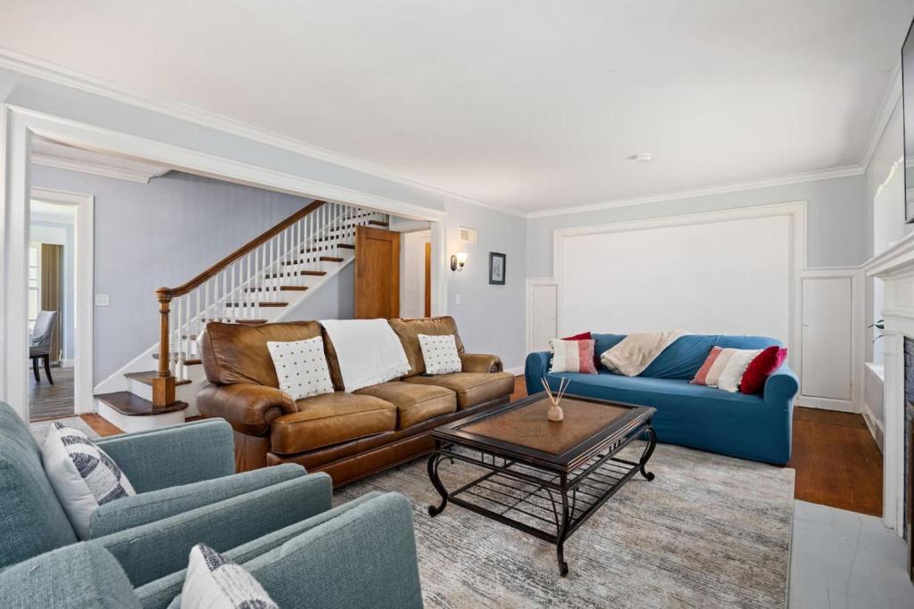 a living room with two couches and a table at Comfortable Private Room | Shared Bath & Kitchen in Peoria