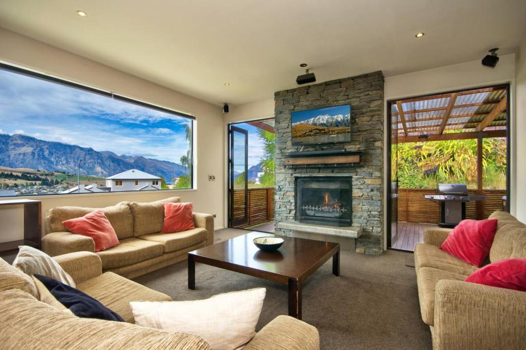 a living room with two couches and a fireplace at Lakeview Lodge Two with Stunning Views in Queenstown
