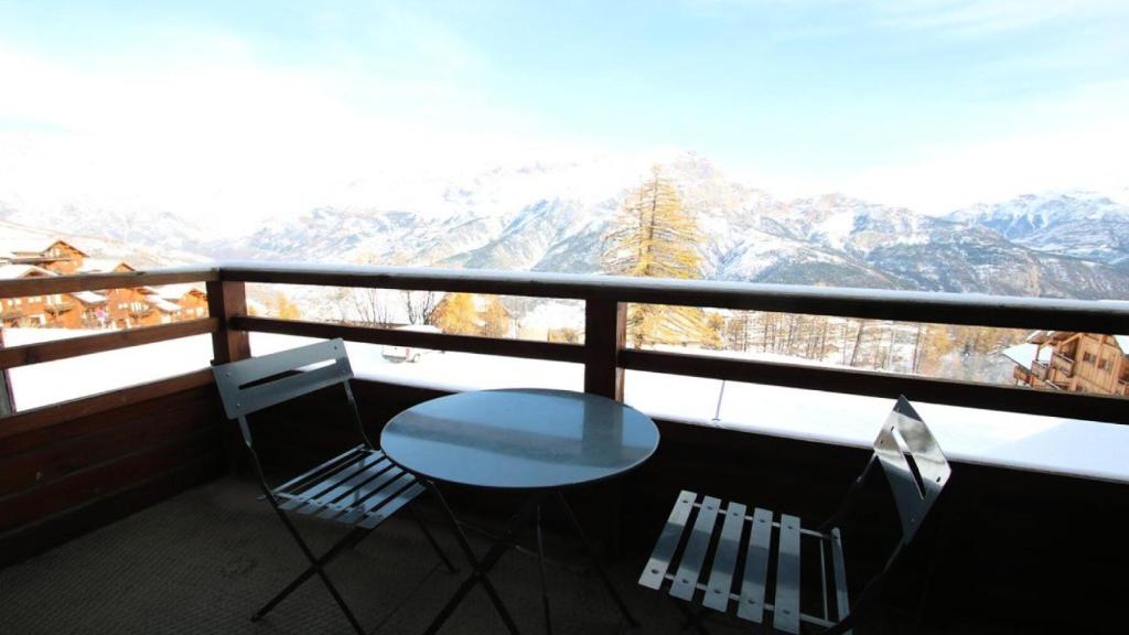 une table et des chaises sur un balcon avec vue sur les montagnes dans l'établissement Résidence Dame Blanche - DBA118 - APPT 1 CHAMBRE + CABINE - BALCON - 6 PERSONNES MAE-7554, à Narreyroux