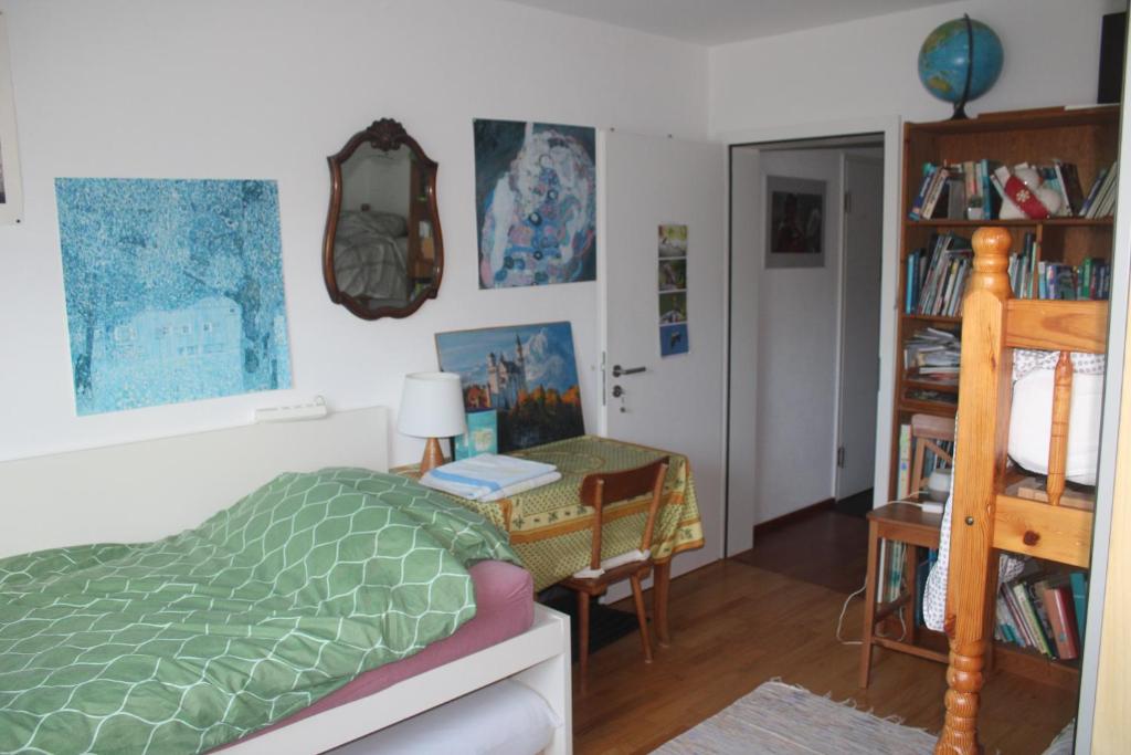 a bedroom with a bed and a desk with a table at Beautiful 14 m2 room in Wünnewil