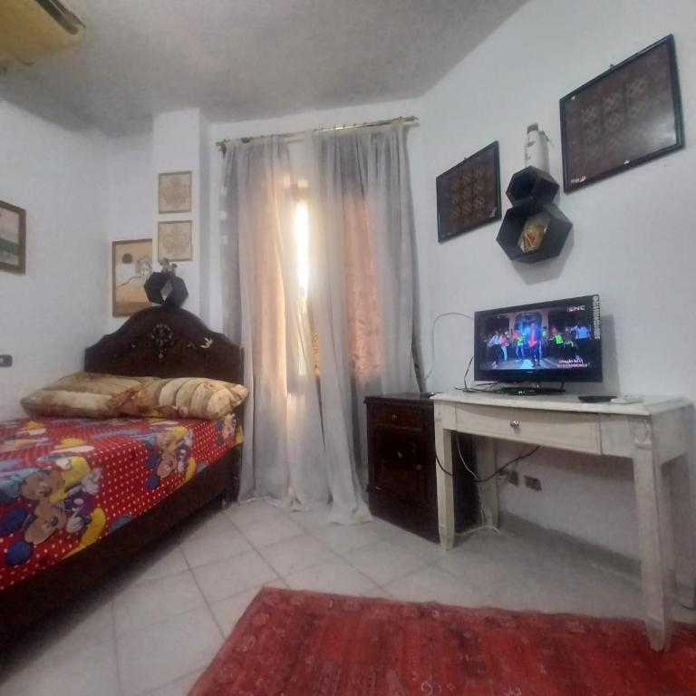 a bedroom with a bed and a desk with a computer at كيرس in Banī Ghālib