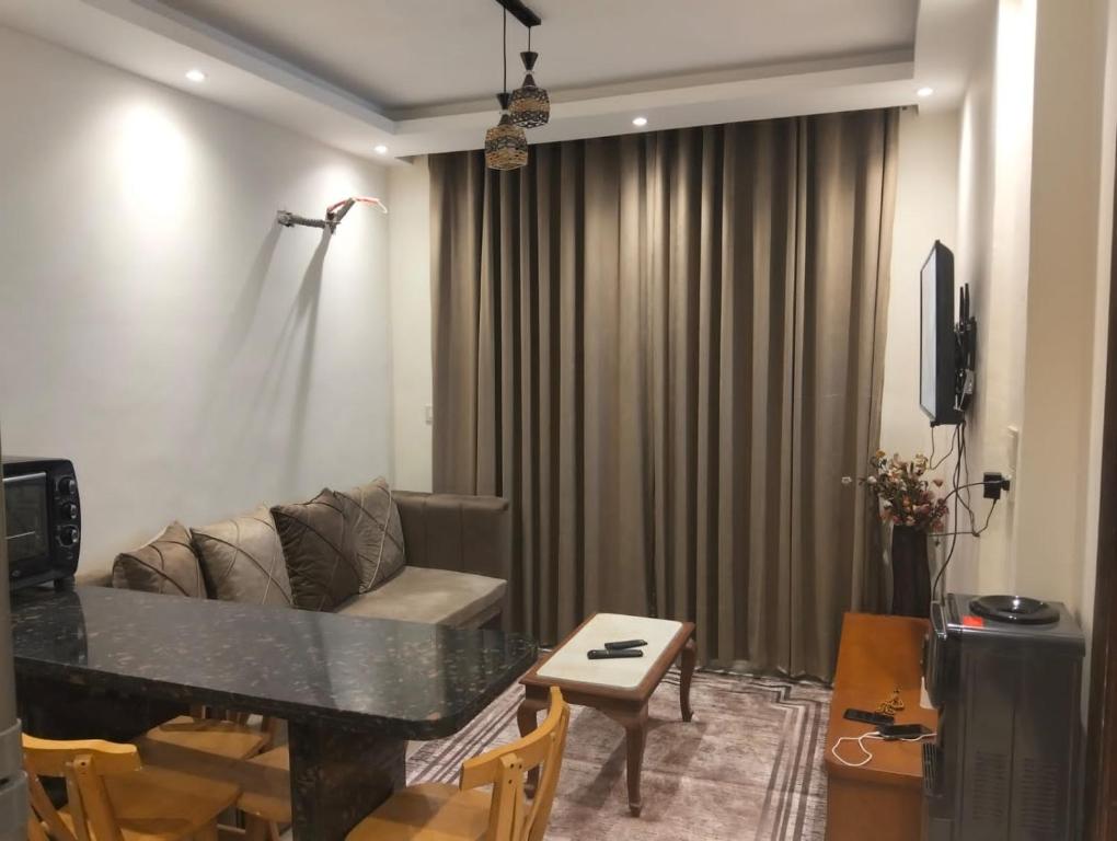 a living room with a couch and a table at شاليه بجولف بورتو مارينا للأسر فقط in El Alamein
