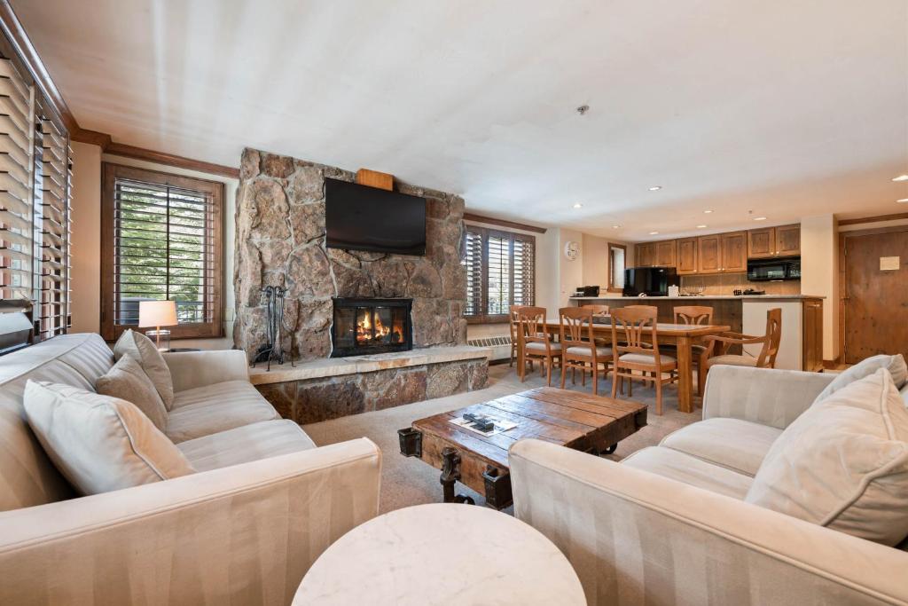 a living room with couches and a fireplace at Lodge Tower 299 One Bedroom Residence in Vail