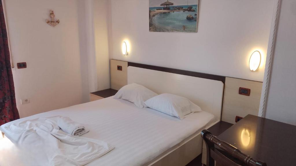 Una cama blanca con dos almohadas encima. en Villa Cimi Subashi Seaside Boutique Hotel, en Durrës