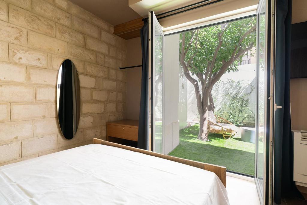 a bedroom with a bed and a large window at I Giardini di Cattaro - History & Comfort in Bari