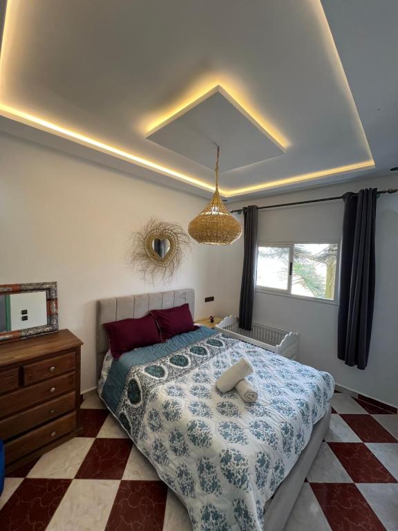 a bedroom with a large bed and a ceiling at Dar Doukkala Oualidia in Oualidia