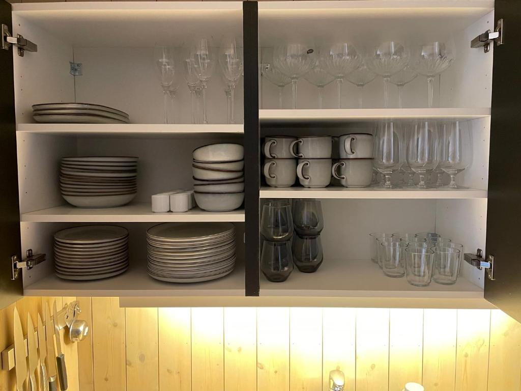 un placard rempli de assiettes, de verres et de vaisselle dans l'établissement Fantastisk utsikt i Hemsedal med ski in og ski ut, à Fausko