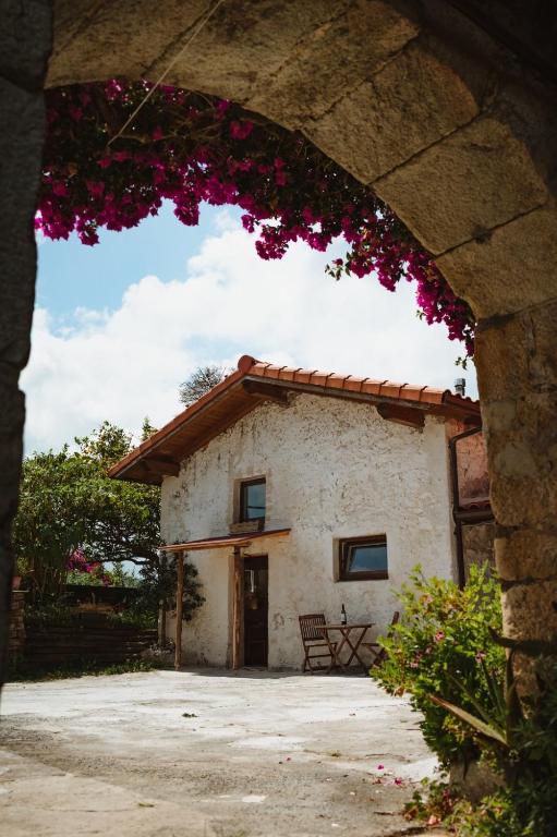 a small house with a building with pink flowers at La casa de los árboles in Isla