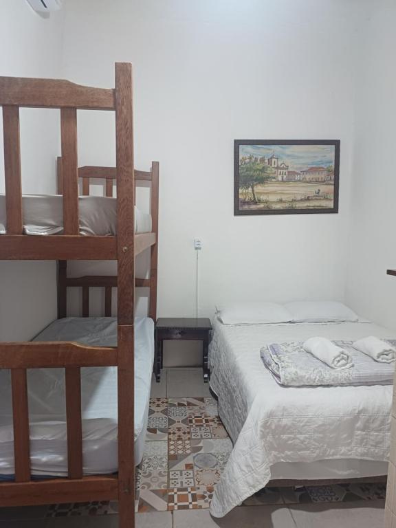 a room with two bunk beds and a bed at Casinha Centro histórico in Paraty
