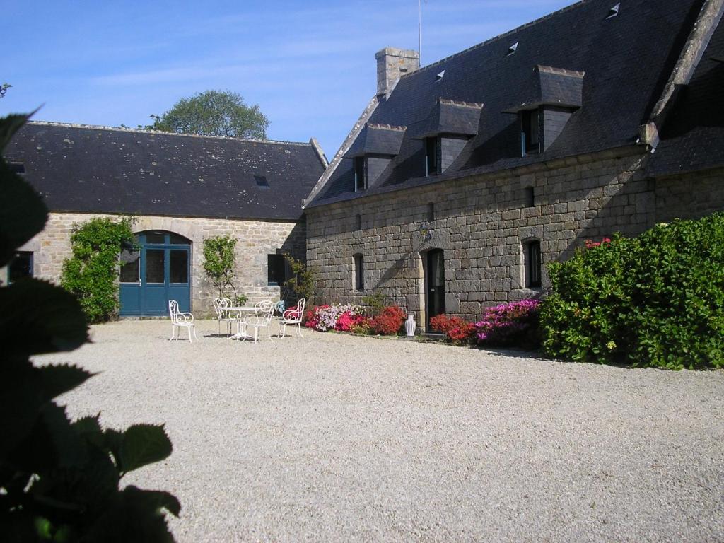 a stone building with a table and chairs in a courtyard at Belle villa en bord de mer à 700 m d'une plage de sable fin in Combrit