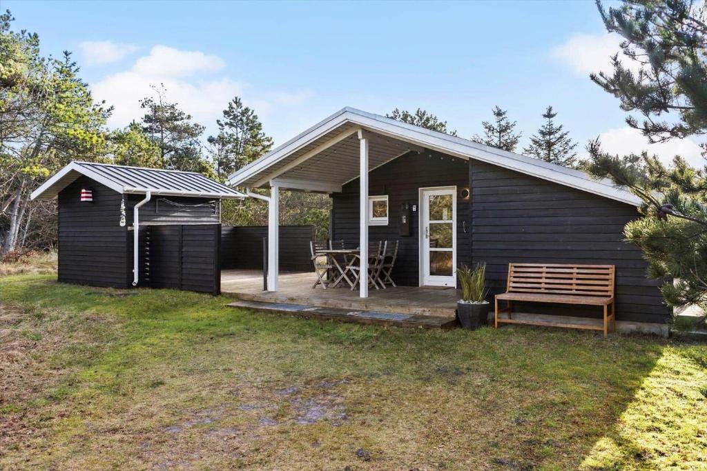 a black shed with a bench in the yard at 1309-Thisted-Blabaervej-2 in Thisted
