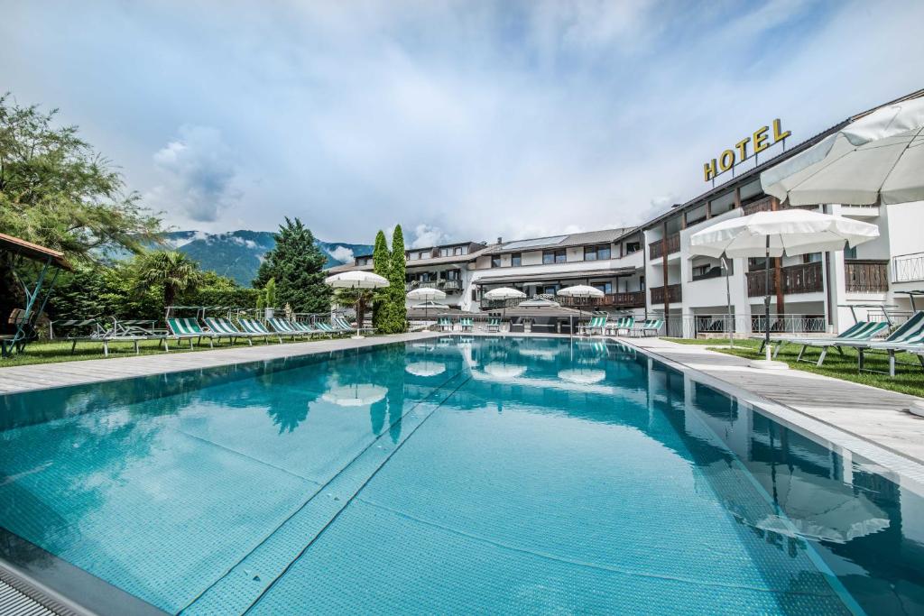 a large swimming pool in front of a hotel at Hotel Förstlerhof in Postal