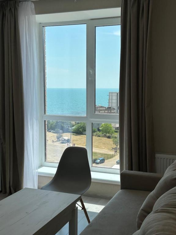 a bedroom with a window with a view of the ocean at Студия с Видом на Море, 9-2 in Chornomorsk