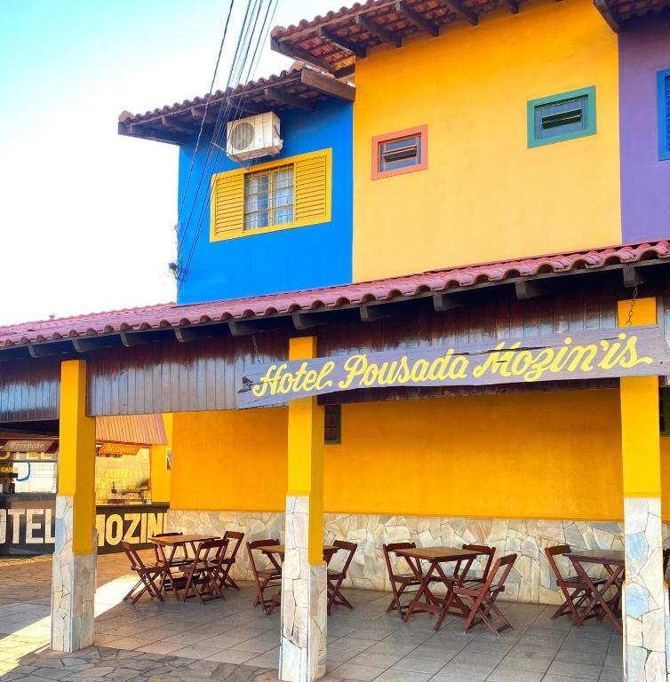 a building with tables and chairs in front of it at Hotel Pousada Mozini's in Tupã
