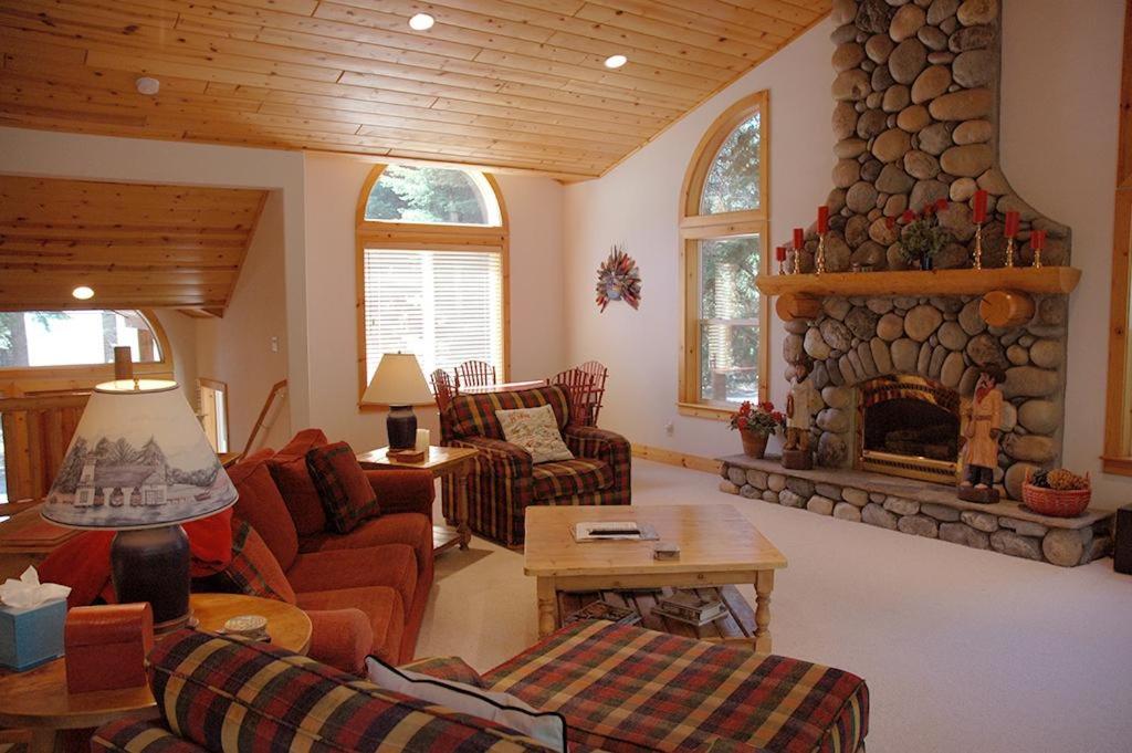 a living room with a stone fireplace in a house at Going By Hauserman Rentals in Homewood