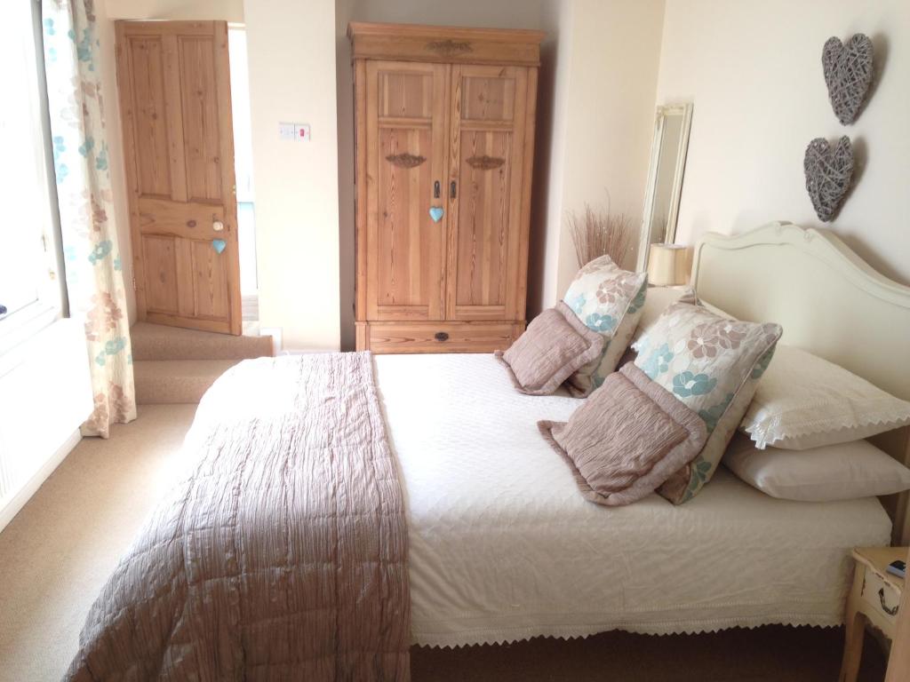 a bedroom with a white bed with pillows on it at Apartment One in Beer