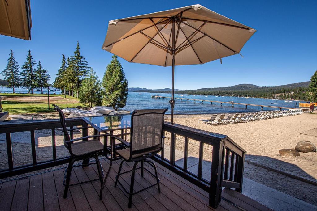 a table and chairs on a deck with an umbrella at Franciscan Lakeside # 29 By Hauserman Rentals in Tahoe Vista