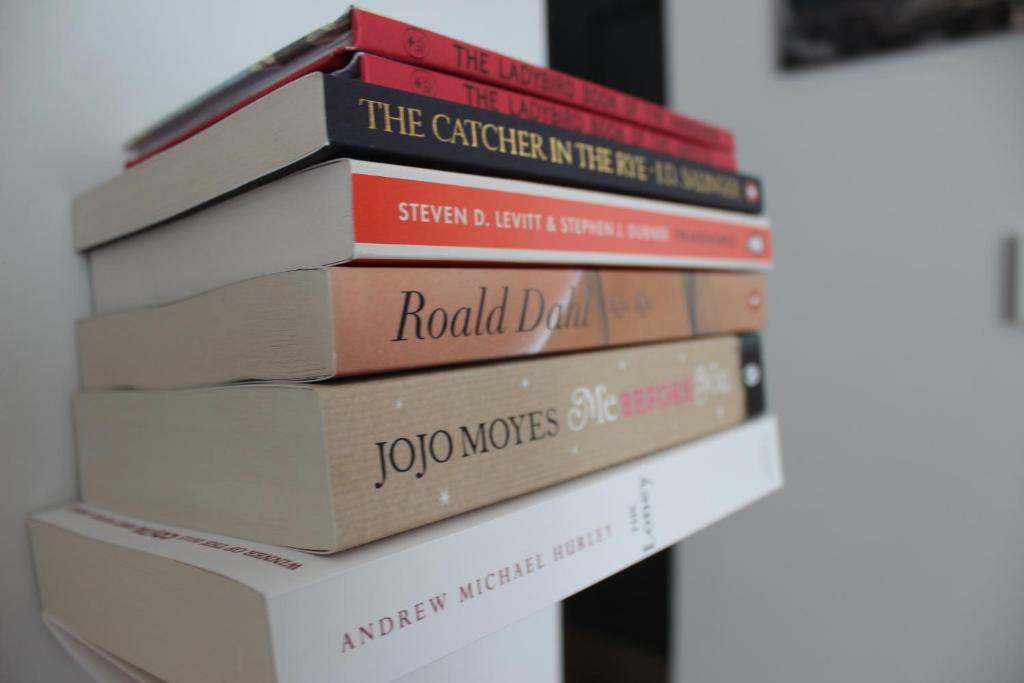 a stack of books sitting on top of each other at The Tilman in Barmouth