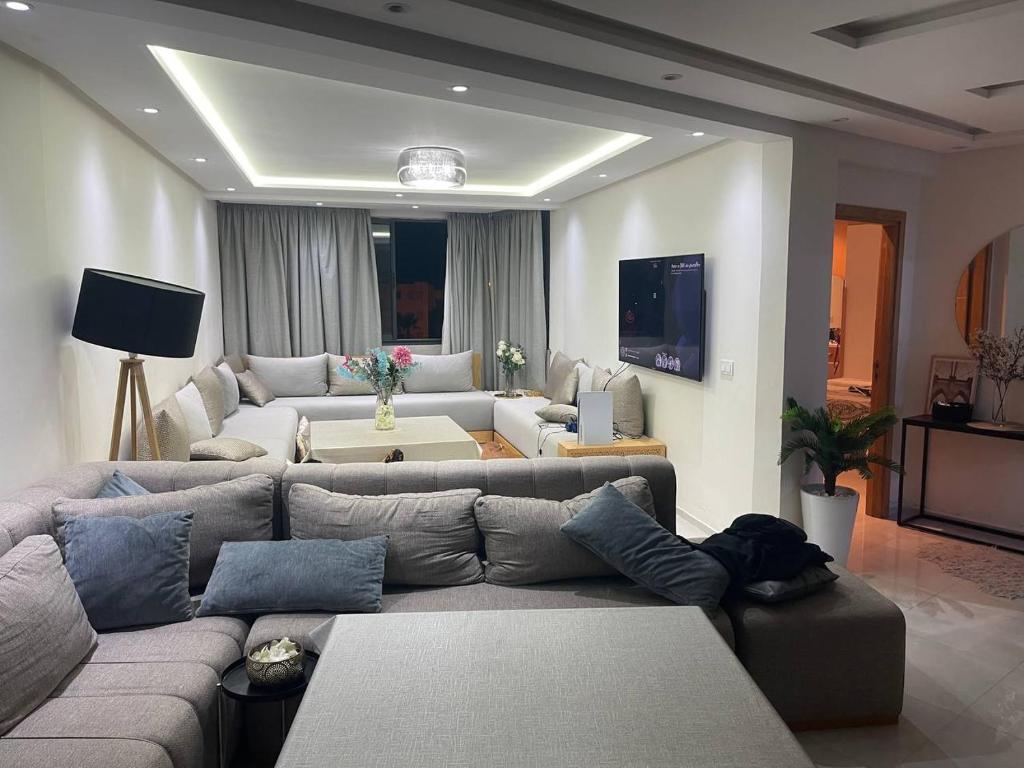 ein Wohnzimmer mit Sofa und Tisch in der Unterkunft magnifique famile appartement a harhoura in Temara