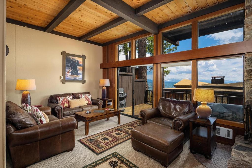 a living room with leather furniture and large windows at Star Harbor # 4 By Hauserman Rentals in Tahoe City