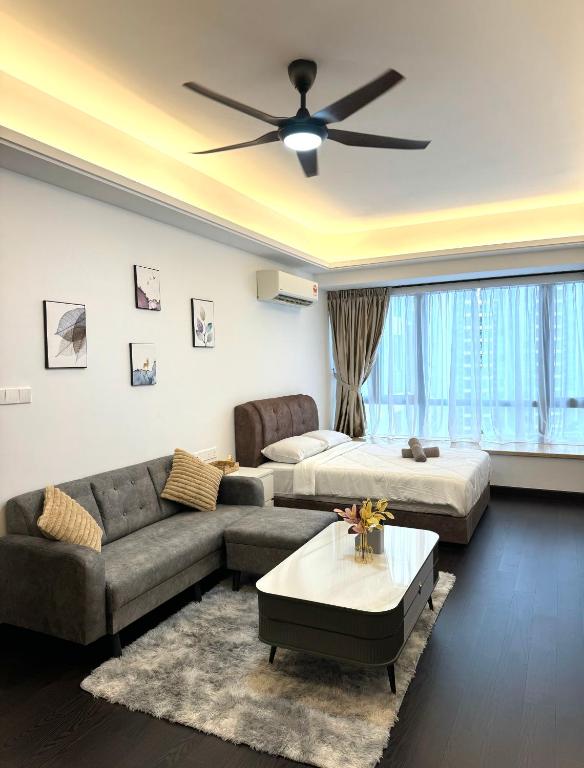 a living room with a couch and a ceiling fan at R&F Princess Cove Swimming View By TGW STUDIO in Johor Bahru